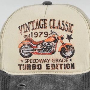 Close-up of vintage motorcycle print and stitching on beige washed baseball cap