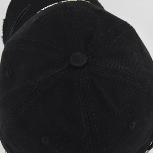Detailed top view of black cotton baseball cap showing seam stitching and distressed details