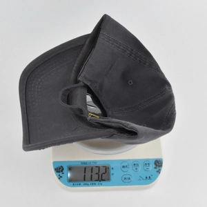 Detailed top view of an embroidered baseball cap on a scale showing its 113.2g weight