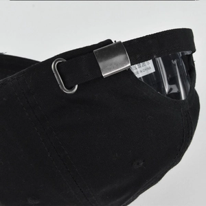 Detail of adjustable metal buckle and strap on back of black cotton baseball cap