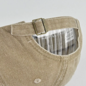Detailed close-up of vintage cotton baseball cap with adjustable bronze metal buckle strap