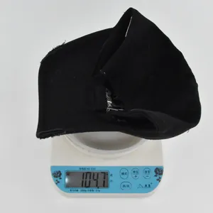 Distressed black baseball cap with cross embroidery weighing 104.7g on scale