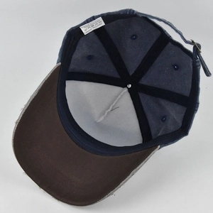Detail of vintage denim baseball cap interior showing 100% cotton label and metal buckle