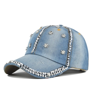 Détails des clous tête de mort argentés et strass brillants sur la casquette jean