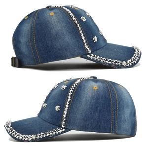 Détail d'une casquette en denim bleu avec décorations de têtes de mort et rivets argentés