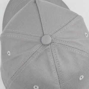 Detailed top view showing grey cotton twill fabric and embroidery eyelets of the baseball cap