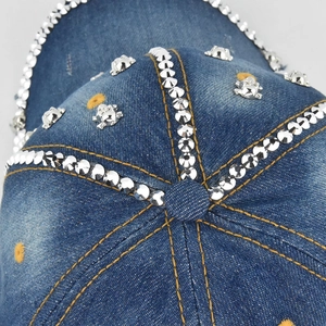 Vue détaillée d'une casquette en denim avec strass argentés et rivets de crâne