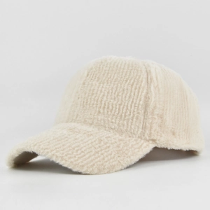 Detailed macro view of the cream-white faux mink fur baseball cap with vertical striped texture