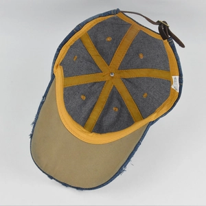 Détail montrant le coton 100% et les coutures jaunes à l'intérieur de la casquette