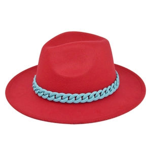Detail of red fedora hat featuring a bold sky blue chunky plastic chain decoration