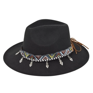 Detail of black fedora hat with ethnic patterned ribbon and silver heart charms
