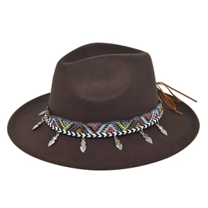 Detail of a brown fedora hat featuring an ethnic woven band and silver leaf charms