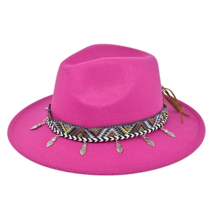 Detail of bright pink wool fedora featuring ethnic woven band and silver heart pendants