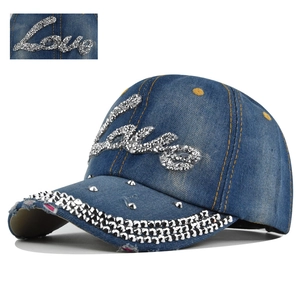 Detailed view of blue denim baseball cap with silver rhinestones and metal rivets