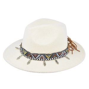 Detail of white wide brim fedora hat with ethnic woven band and heart charms with fringe