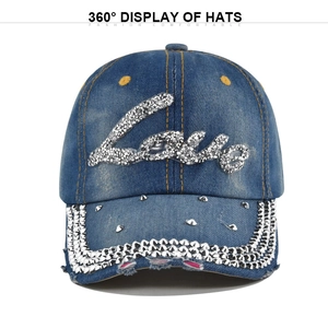 Detailed close-up of blue denim baseball cap featuring Love rhinestone and metal studs