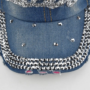 Macro shot of blue washed denim baseball cap featuring silver rhinestones and distressed edges