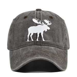 Détail du tissu denim délavé et de la silhouette de cerf blanc sur la casquette de baseball