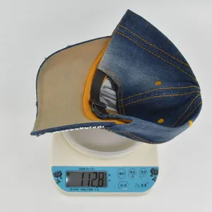 Mesure détaillée du poids de la casquette en jean délavé affichant 112,8 g sur une balance