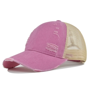 Detalle de gorra de béisbol rosa desgastada con malla transpirable de color beige