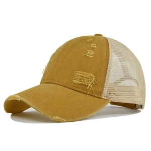 Detalle de gorra trucker amarillo mostaza con agujeros vintage y malla transpirable