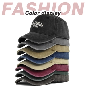 Vertical stack of washed cotton baseball caps in eight vintage colors with embroidery