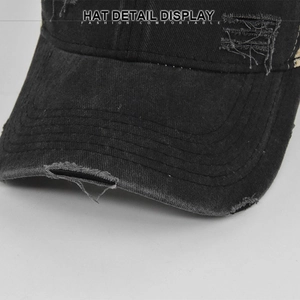 Vista detallada de la gorra vintage negra lavada con tejido desgarrado y bordes deshilachados