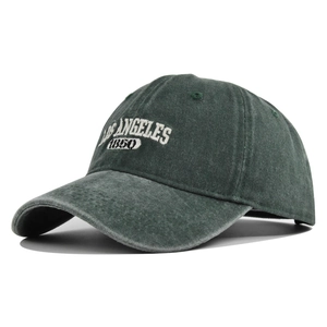 Detail view of deep green vintage washed cotton baseball cap with white embroidery