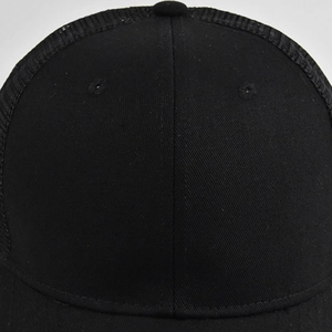 Detailed close-up of the breathable mesh structure and stitching on a black trucker cap