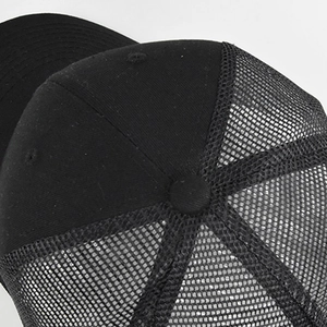 Close-up of black mesh trucker hat showing breathable texture and structured back panels