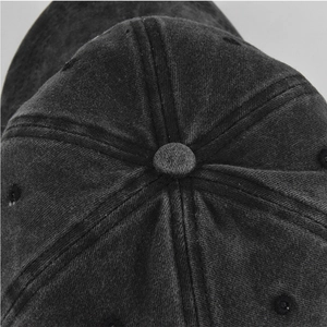 Close-up of the six-panel crown and top button on a washed cotton baseball cap
