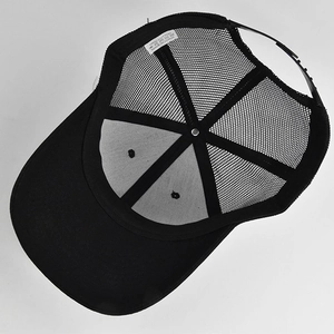 Detail of adjustable strap and breathable mesh back on the black trucker baseball cap