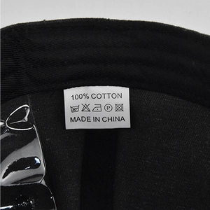 Detailed macro view of 100% cotton material and wash label inside the baseball cap