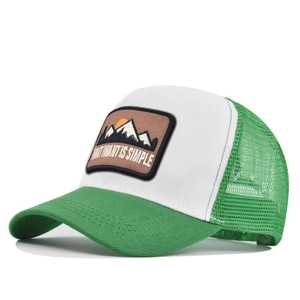 Detail of mountain embroidery patch on green and white mesh trucker hat for outdoor sun protection