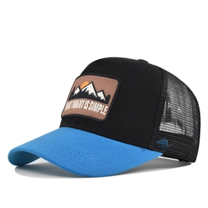 Side view of mountain embroidery on mesh trucker hat with contrast blue brim