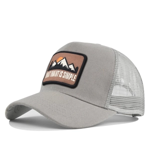 Detailed side view of grey trucker hat with mountain embroidery and mesh back panel