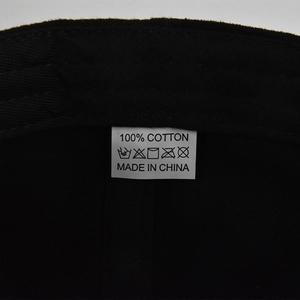 Detail macro-opname van het 100% katoenen waslabel en twill stof op een zwarte baseballpet