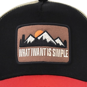 Close-up of mountain embroidery and What I Want Is Simple text on mesh baseball cap