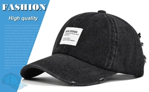 Detailed view of dark grey distressed denim baseball cap with vintage patch and frayed edges