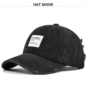 Close-up of distressed black denim baseball cap with vintage patches and frayed details