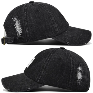 Detail view showing distressed denim texture and side woven label on the black baseball cap