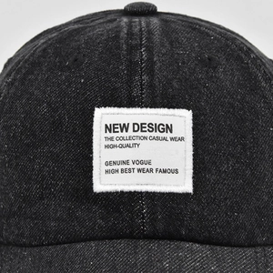 Close-up of vintage washed denim baseball cap featuring a white embroidered logo patch