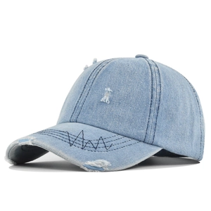 Detail of light blue washed denim cap featuring distressed holes and wavy black stitching