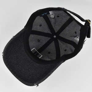 Internal view of distressed black denim baseball cap showing sweatband and adjustable buckle