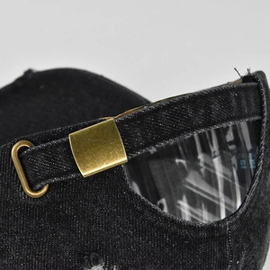 Detail of vintage denim baseball cap showing adjustable brass metal buckle and stitching