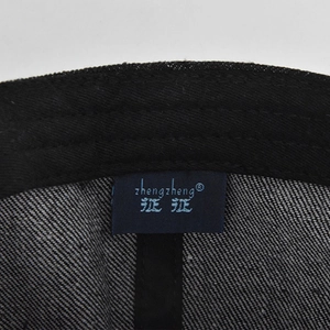 Detail shot of navy brand label and fine stitching inside the distressed denim baseball cap