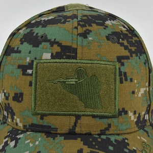 Dettaglio del cappello tattico mimetico con ricamo silhouette cecchino su velcro