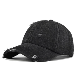 Vintage distressed black denim baseball cap with retro frayed edges and street style design