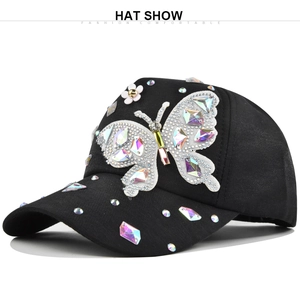 Detailed view of butterfly rhinestone applique and crystal studs on black baseball cap