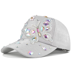Close-up of crystal butterfly on silver baseball cap with colorful rhinestones detail